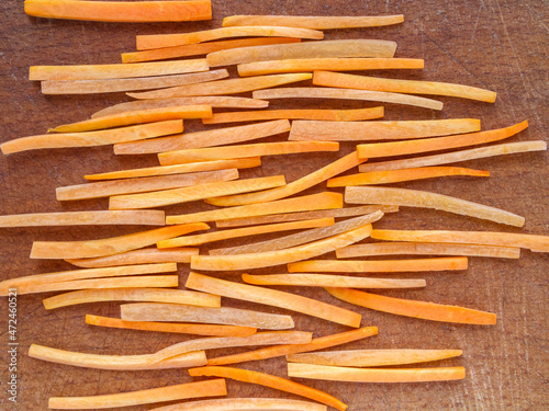 Closeup of julienne carrot on a wooden board.