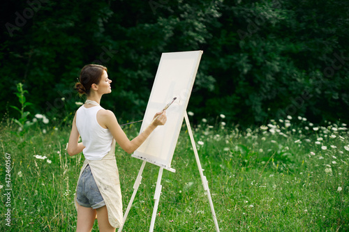 woman artist with palette of paints drawing easel nature hobby