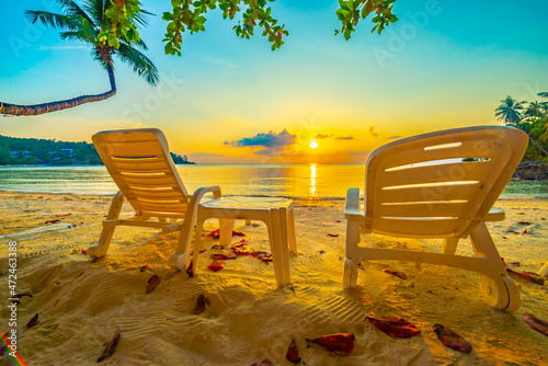 Fototapeta Naklejka Na Ścianę i Meble -  Beautiful tropical sunset scenery, two sun beds, loungers, umbre