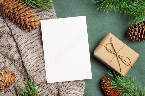 Christmas or New Year greeting card mockup with gift box and fir tree branches with cones