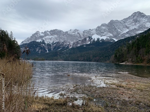 Eibsee in Autumn November with sunshine, trees and the Zugspitze mountain in the background, Bavaria Allgäu Germany 