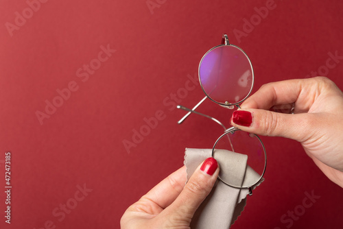 Pedicured hands cleaning glasses with mist