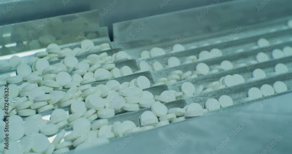 pharmaceutical production. white round pills move along the modern production line.close-up. pharmaceutical production. white round pills move along the modern production line.close-up.