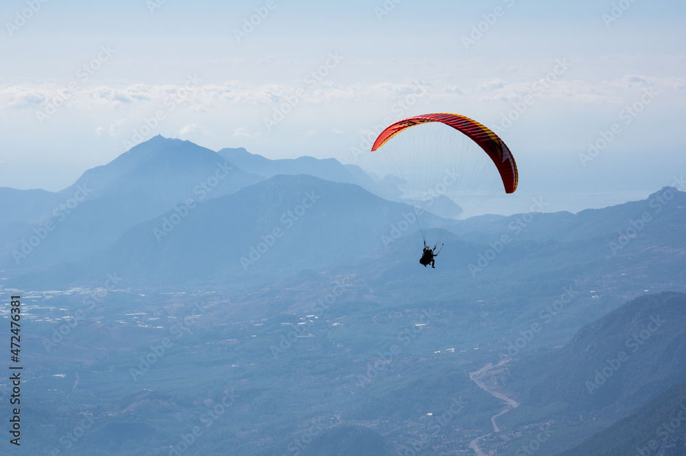 Paraglider flying over mountains