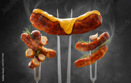 a whole and sliced grilled hot fried sausage is strung on a meat fork