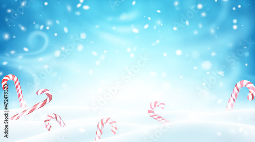 Christmas candy canes on snowy background.