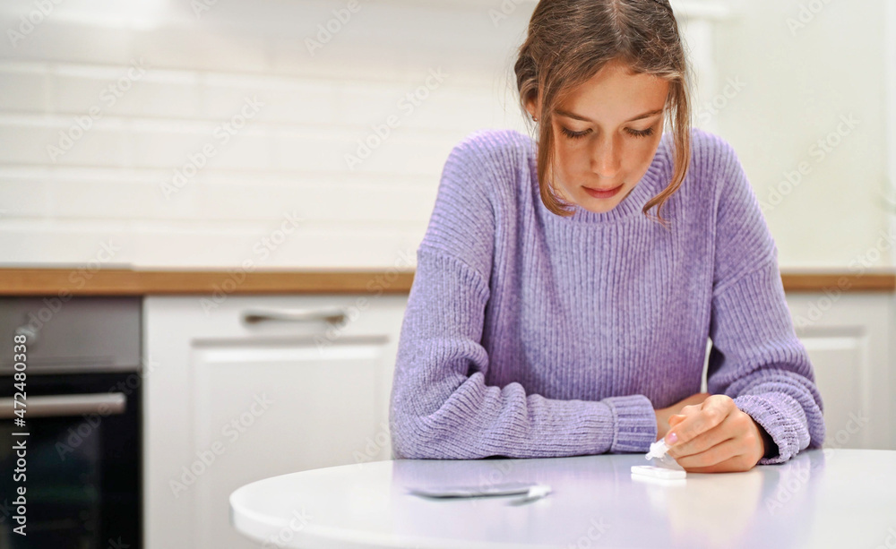Schoolgirl doing express COVID-19 antigen test at home. Schoolgirl doing express COVID-19 antigen test at home.