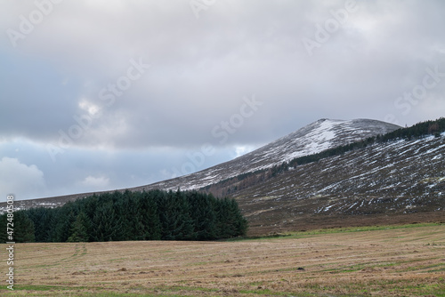 DUFFTOWN  MORAY  SCOTLAND - 1 DECEMBER 2021  This is the peak of Moray  Ben Rinnes with some snow coverage and the sun peeking at times in Dufftown  Moray  Scotland on 1 December 2021.