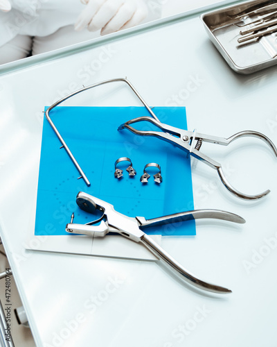 Medical tools. Dental tongs, cofferdam scarf and frame on blue background.