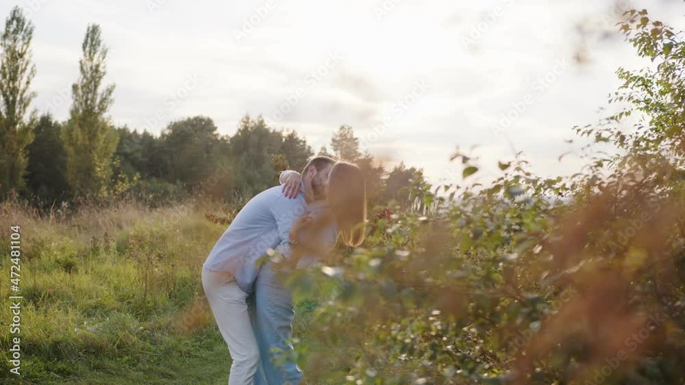 Romantic couple walking in park. Portrait of happy man and woman hugging and kissing with passion at summer outdoors. Romantic couple walking in park. Portrait of happy man and woman hugging and kissing with passion at summer outdoors.