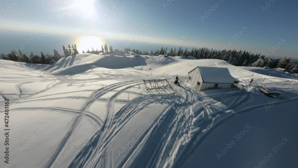 Aerial view man extreme riding on snowmobile surrounded by snowy slope Mamdziskha mountain sports FPV drone. Enjoying speed driving at wilderness nature landscape Black Sea Abkhazia sunny day Aerial view man extreme riding on snowmobile surrounded by snowy slope Mamdziskha mountain sports FPV drone. Enjoying speed driving at wilderness nature landscape Black Sea Abkhazia sunny day