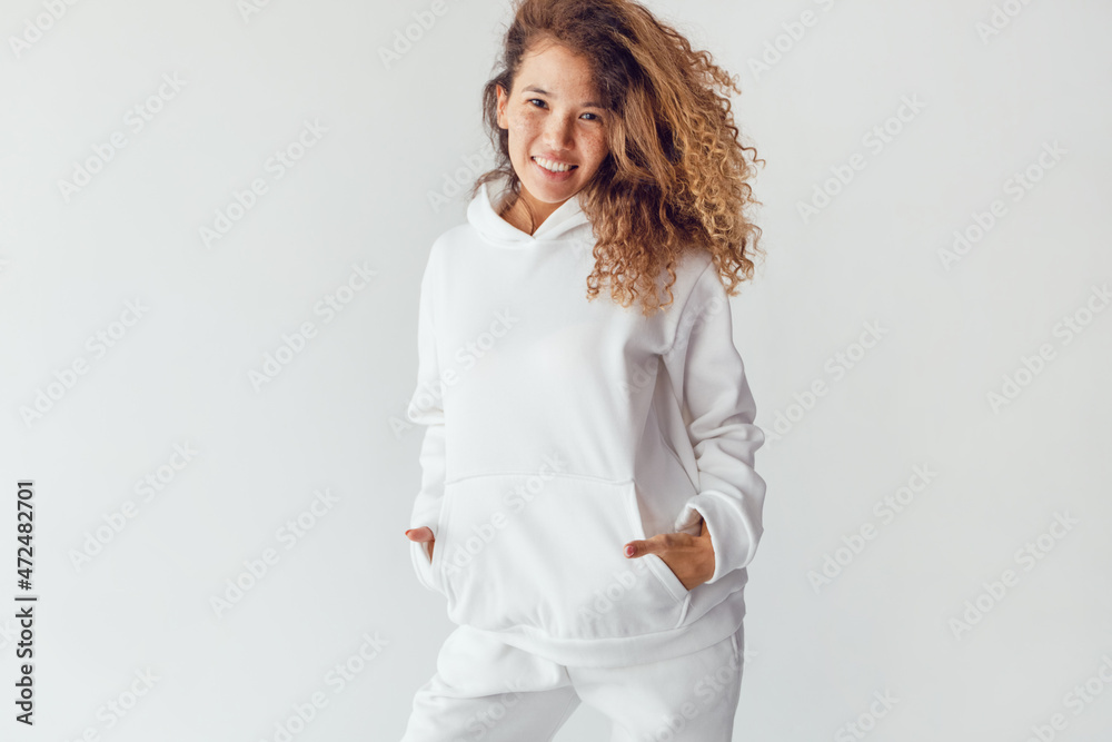 Attractive woman with thick curly hair in a white suit of hoodies and sweatpants. Mock-up. Attractive woman with thick curly hair in a white suit of hoodies and sweatpants. Mock-up.