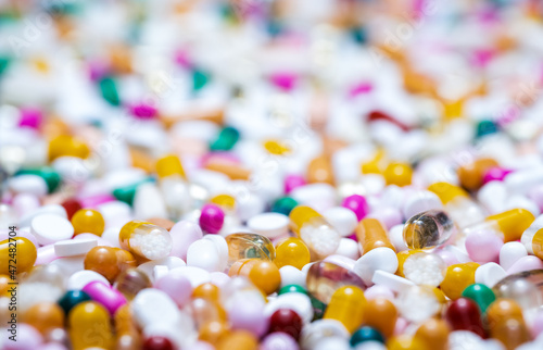 Tablets, pills, capsules and dragees background. Colorful pile of medicine, drug, dietary or nutritional supplement concept with selective focus.