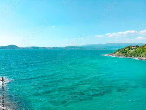 Coastal view of beautiful Aegean sea and seashore. Aerial drone shot of summer holiday landscape with blue sky.