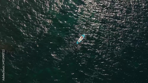People on a blue kayak in the open sea, a view from a height