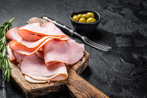 Pork ham slices on cutting board, Italian Prosciutto cotto. Black background. Top view. Copy space photo
