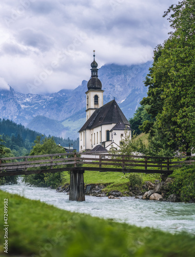 A wood bench with parish church, river abd mountains in background. berchtesgaden, Ramsau Germany