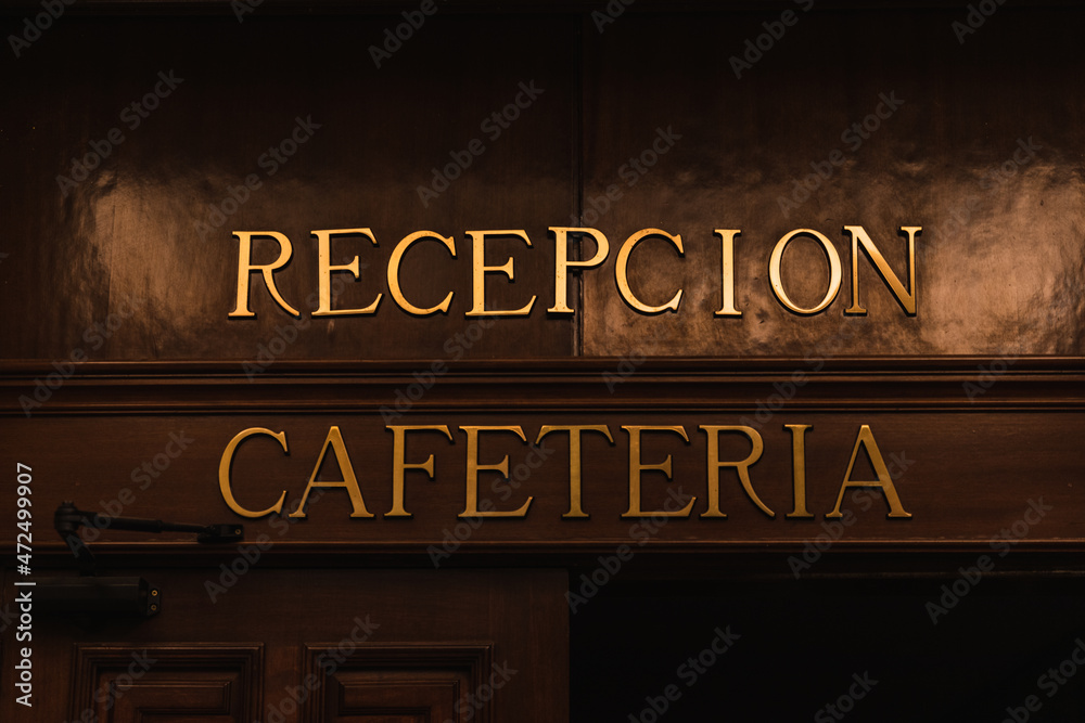 Golden entrance sign to reception and cafeteria with wooden door frame Golden entrance sign to reception and cafeteria with wooden door frame