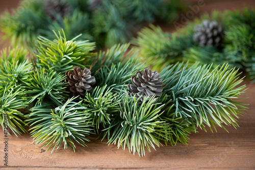 Christmas background pine branches with cones on a wooden background.