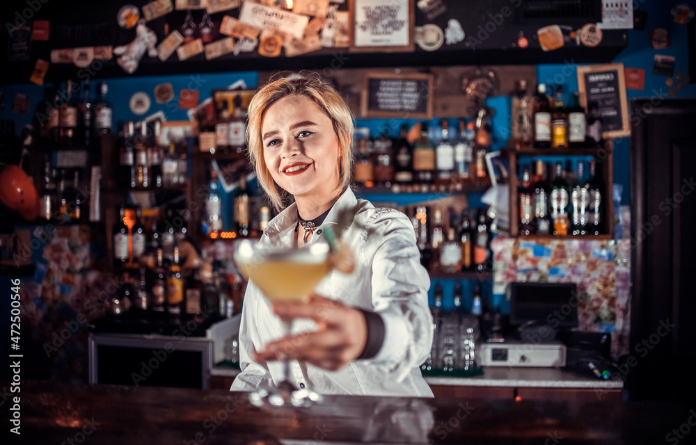 Girl bartender makes a cocktail in the pothouse