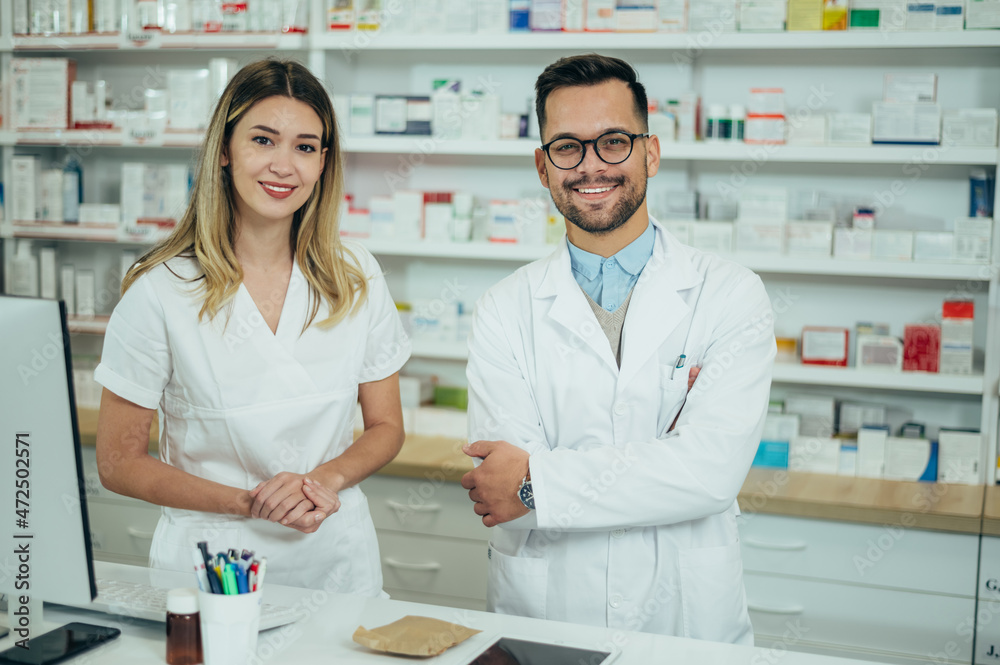Happy young male and female colleagues pharmacist working in a pharmacy
