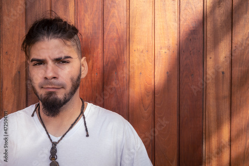 Male 25 to 30 years old of Hispanic race and hippie appearance looking straight into the camera