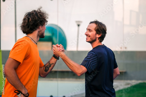Portrait of handshake of two padel tennis players - Padel players embracing after win a padel match