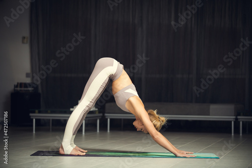 Attractive girl practices yoga in the interior.