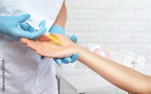 The cosmetologist makes injections on the palms of a woman against hyperhidrosis. Women's cosmetology, skin care.