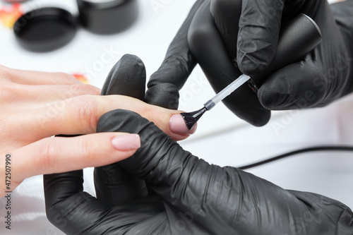 Coating nails with gel polish in the beauty salon. Professional care for hands. © Dimid