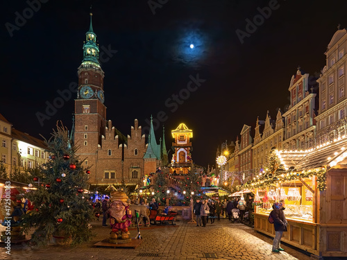 Wroclaw, Poland. Christmas market on Market Square close to Old Town Hall in night. Figures of Dwarfs, which are symbols of the city of Wroclaw, are located in the foreground.