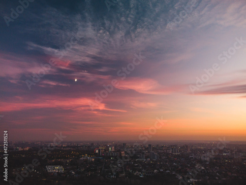 Aerial scenic vivid colorful sunset clouds on epic skyscape with moon. Kharkiv city center  residential district streets in evening light