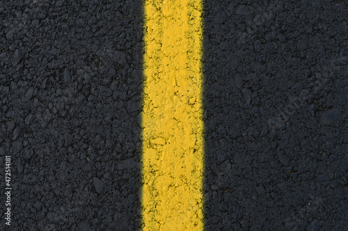 Yellow line on fresh asphalt to mark road works or temporary obstruction.  © kyrychukvitaliy