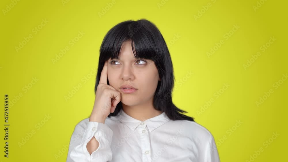 Thoughtful woman. The woman who suddenly had an idea, thoughtful. The background color is yellow. Thoughtful woman. The woman who suddenly had an idea, thoughtful. The background color is yellow.