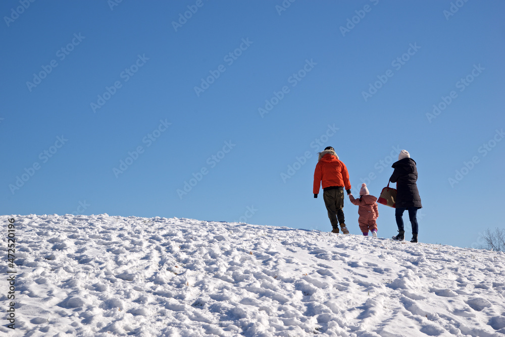 Happy family in outdoors  - Father, mother and child are having fun on snowy winter walk in nature.