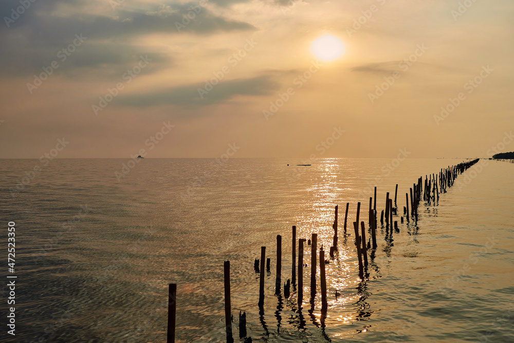 sunset over the sea with wooden post sunset over the sea with wooden post