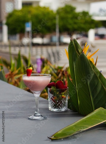 Creamy pink cocktail in tall glass in bar restaurant garden perfect for social media or posters