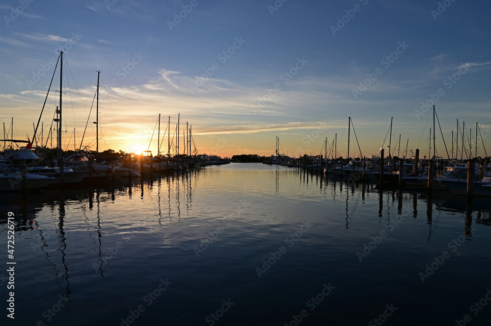 Boats docked in marina in Miami, Florida at sunrise on clear autumn morning.