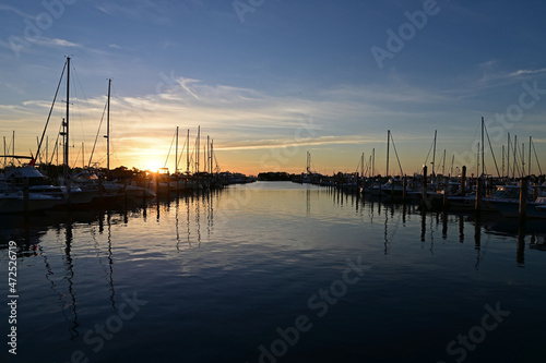 Boats docked in marina in Miami, Florida at sunrise on clear autumn morning.