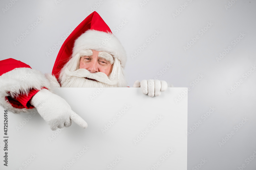 Santa Claus points to an empty white space. Promotional offer for Christmas. Santa Claus points to an empty white space. Promotional offer for Christmas.