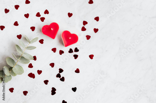 Candle with scattered red hearts photo