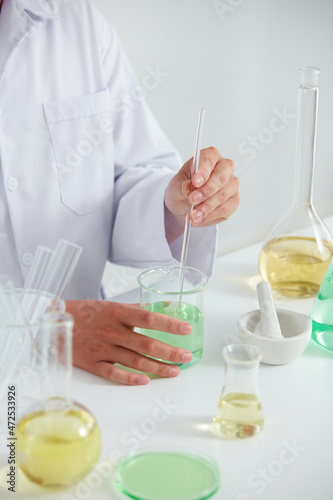 Scientist research with petri dish and a white background in laboratory , color liquid in a test tube and scientist for cosmetic advertising , photography science concept