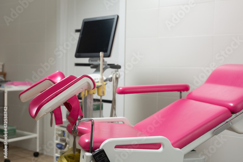 Photo of a pink gynecological chair in an equipped office of a modern medical clinic photo