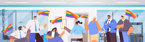mix race businesspeople holding lgbt rainbow flags gay lesbian love parade pride festival transgender love concept