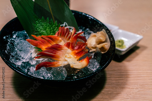 Japanese Stimpson surf clam or Clam Pinion or hokkigai sashimi with ice and glass black bowl on the table. Fresh raw seafood of Japanese healthy menu. photo