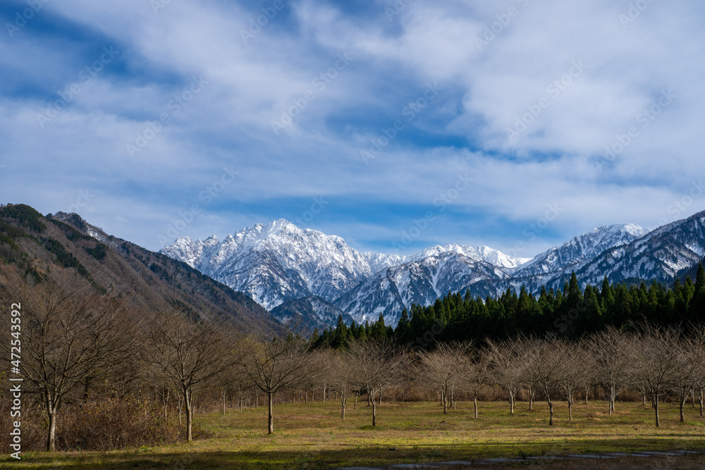 富山県立山町、上市町にある剱岳を見るために雪が積もる冬の中山を登山する風景 A view of climbing a mountain in winter with snow to see Tsurugidake in Tateyama and Kamiichi towns, Toyama Prefecture.