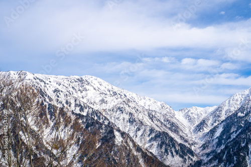 富山県立山町、上市町にある剱岳を見るために雪が積もる冬の中山を登山する風景 A view of climbing a mountain in winter with snow to see Tsurugidake in Tateyama and Kamiichi towns, Toyama Prefecture.