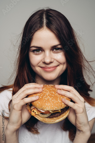 woman with a hamburger in her hands a snack fast food close-up