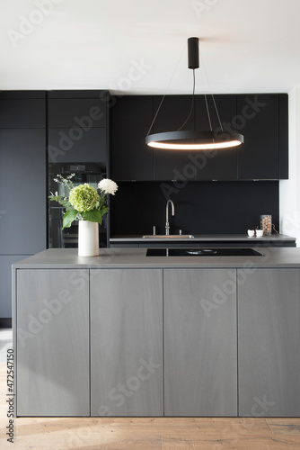 Grey kitchen island and black cupboards