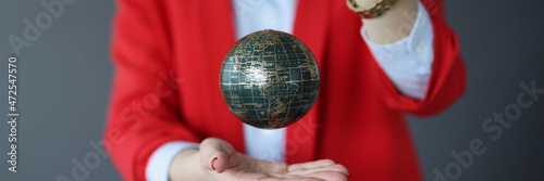 Woman in a business suit holds ball with world map